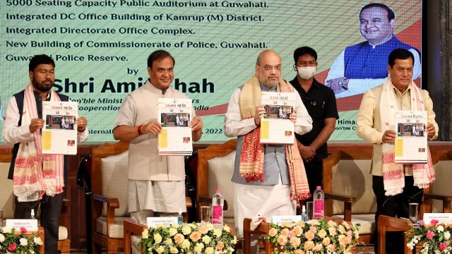 Union Home Minister Amit Shah flanked by Chief Minister Himanta Biswa Sarma and Union Minister Sarbananda Sonowal releases Assam government’s official newsletter ‘Asom Barta’ at a programme in Guwahati Tuesday. Image: Indigenousherald 